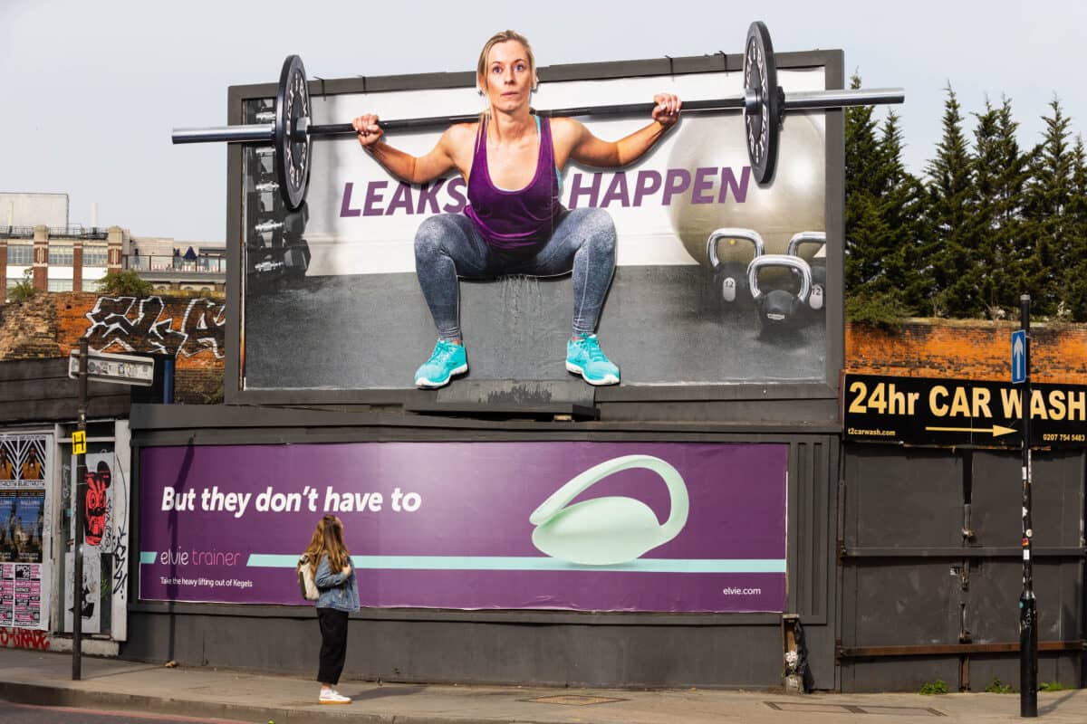 Billboard of a woman weightlifting with a woman looking at the board