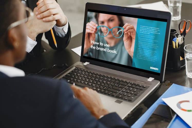 Team look at a computer screen where the IGNIFI brandbook is on the screen