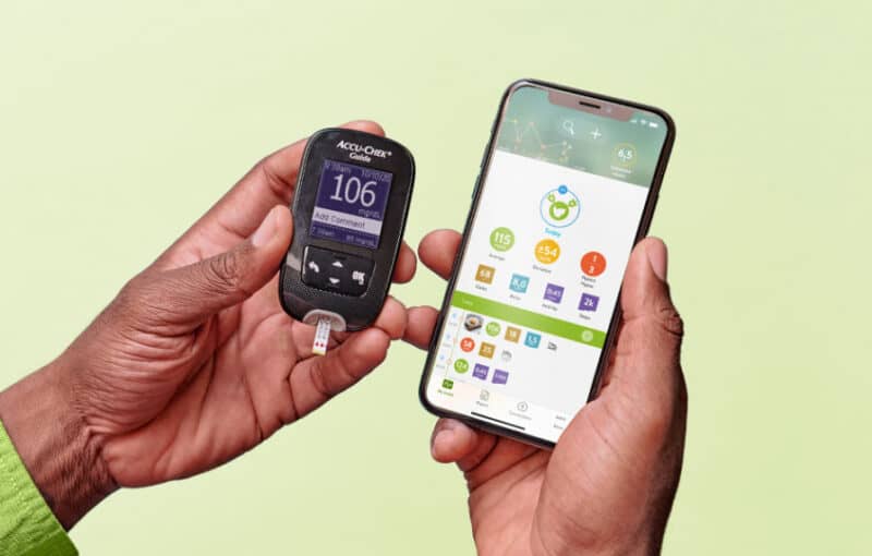 Someone holding their diabetes monitor and phone with their data
