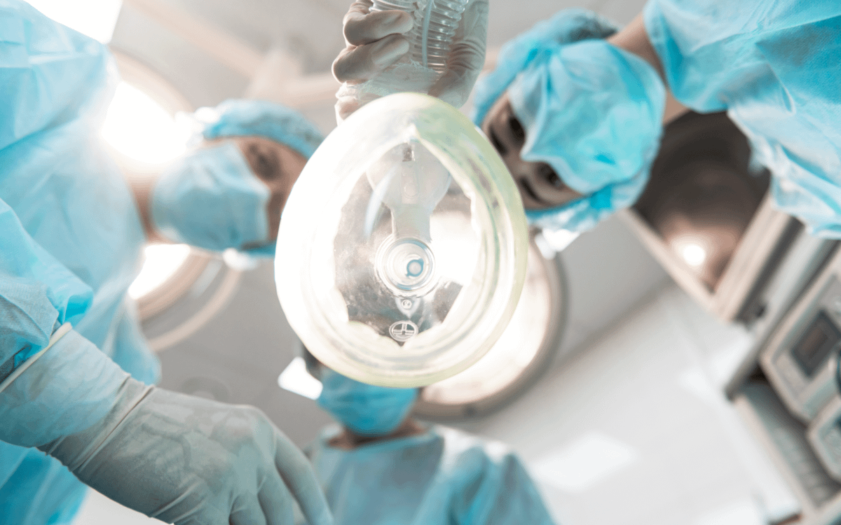 Healthcare professionals putting a mask over a patients face