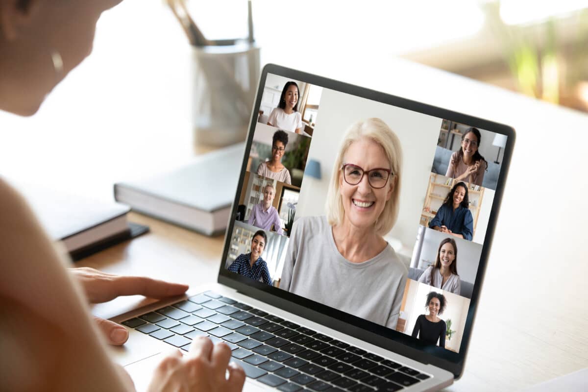 View over girl shoulder to computer screen with a group of diverse age and ethnicity women