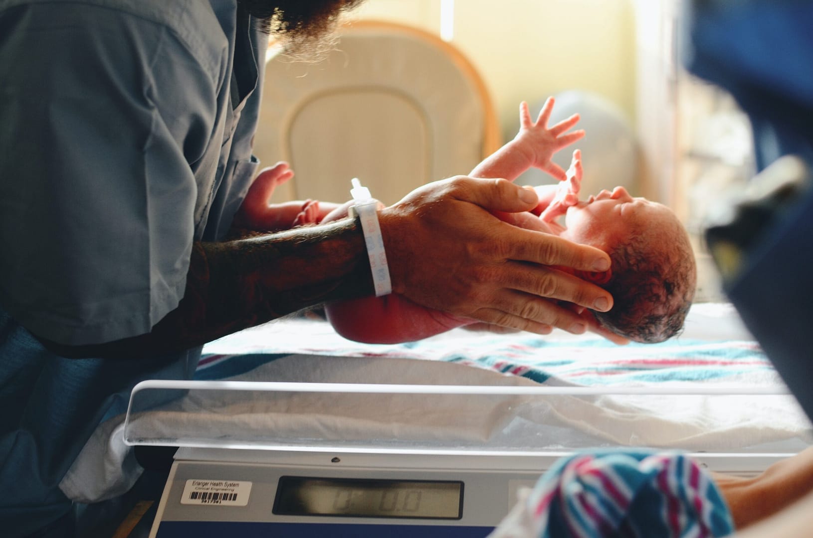 New born baby being weighed by midwife